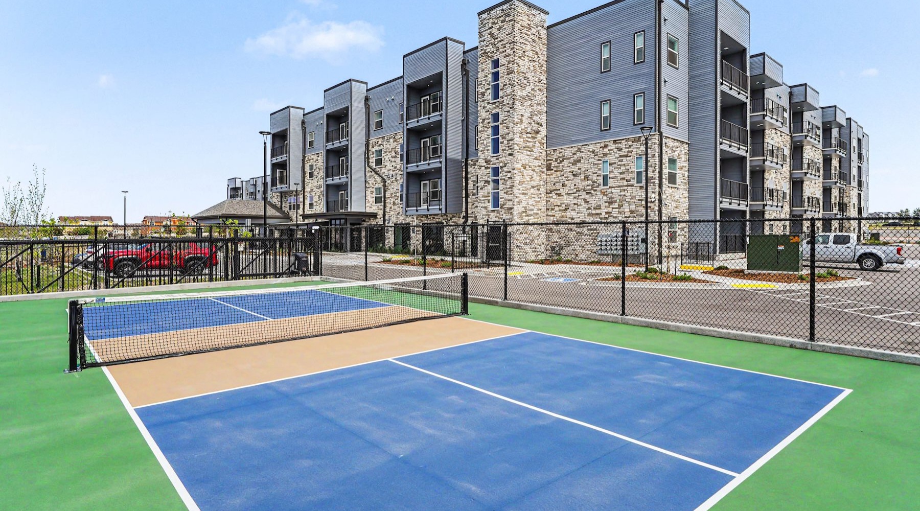 a pickleball court with a large building behind it