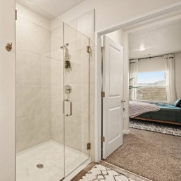 a glass sower and bedroom in view