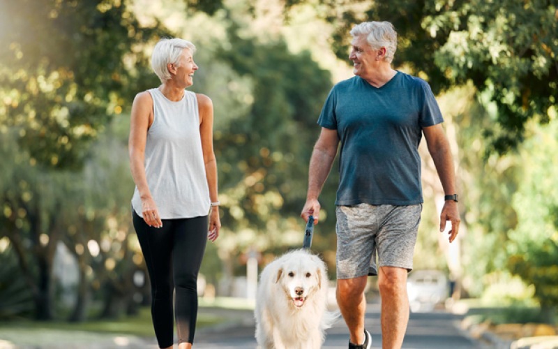 man and woman walking a dog