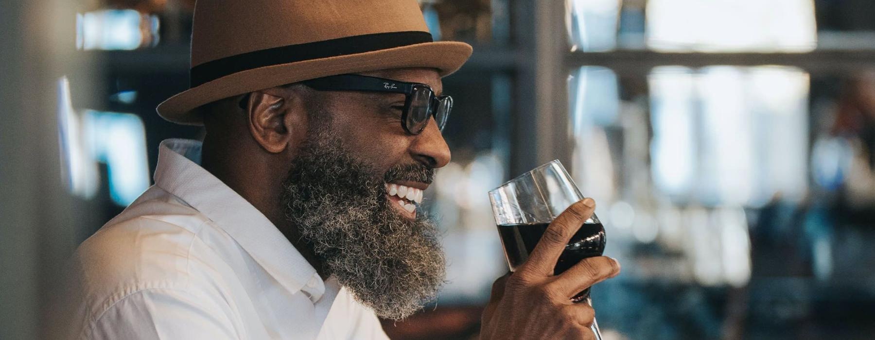 man sitting with a glass of wine in his hand